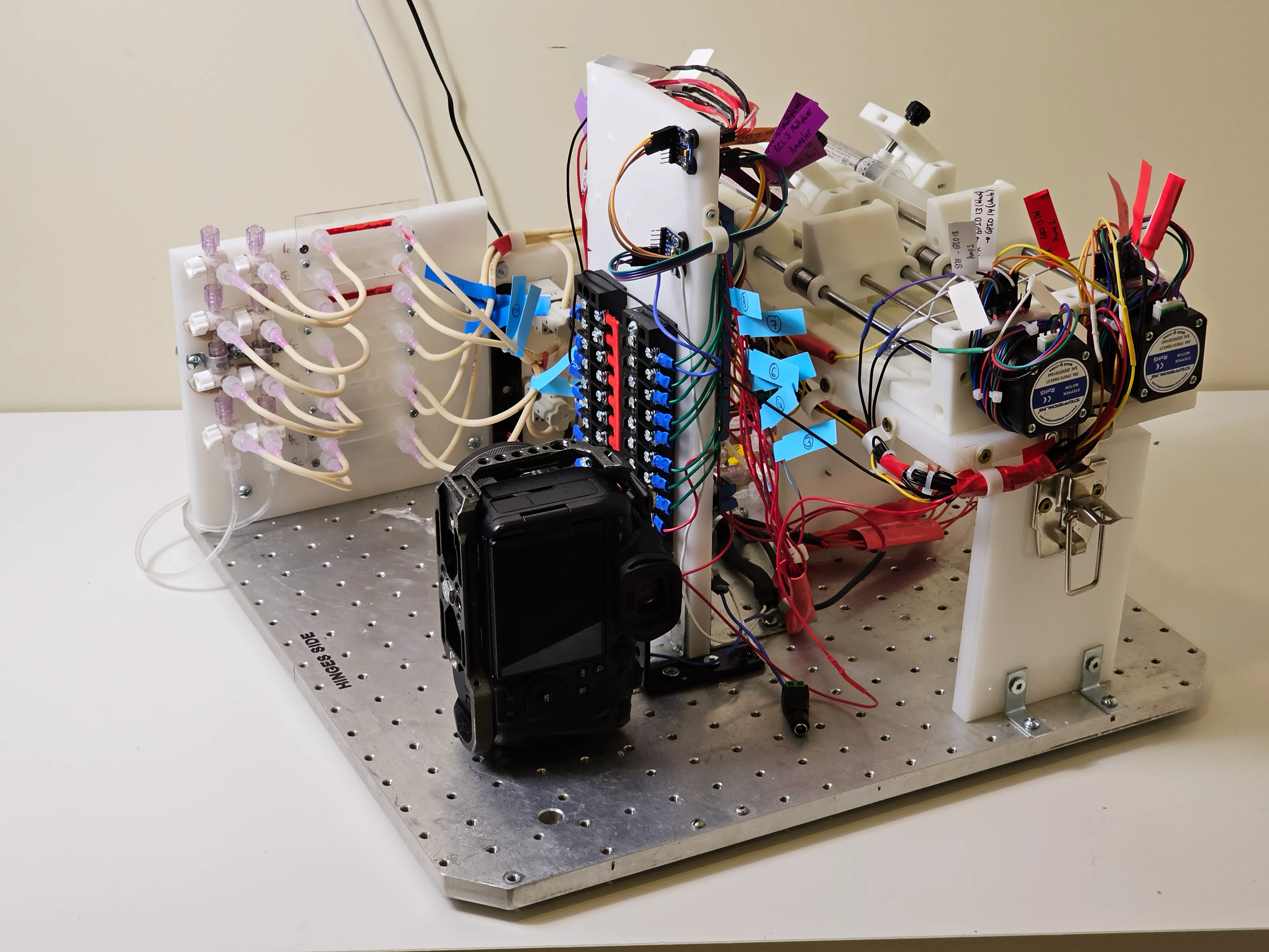 Assembled CLOT-LESS payload with microchannels, tubing, pressure sensors, pumps and camera mounted on a baseplate.
